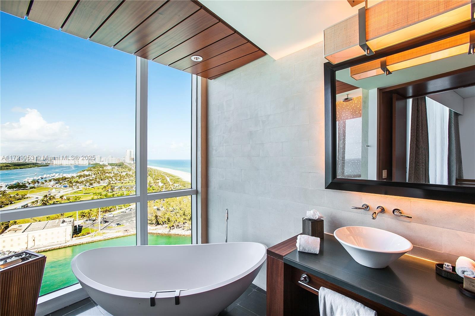A modern bathroom features a freestanding tub, a vessel sink, and floor-to-ceiling ocean view windows — 10295 Collins Ave # 1612, Bal Harbour FL 33154, BAL HARBOUR, FL