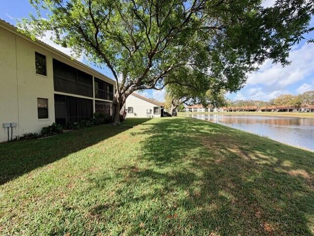 A two-story apartment building sits beside a grassy lawn and a calm lake — 9784 Pavarotti Terrace # 102, Boynton Beach FL 33437, BOYNTON BEACH, FL