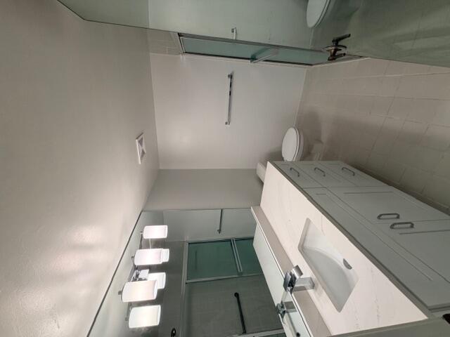 A bathroom features a white vanity with a stone countertop, a mirror, and a shower — 9784 Pavarotti Terrace # 102, Boynton Beach FL 33437, BOYNTON BEACH, FL