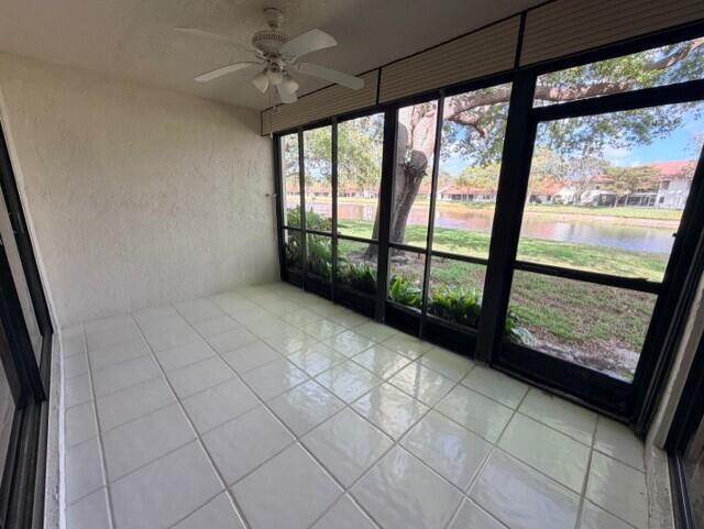 A tiled sunroom features a ceiling fan and large screened windows overlooking a canal — 9784 Pavarotti Terrace # 102, Boynton Beach FL 33437, BOYNTON BEACH, FL