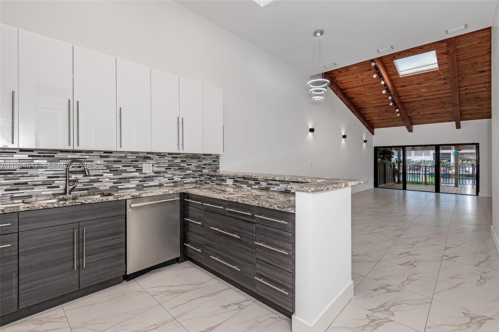 A kitchen with dark wood lower cabinets, white upper cabinets, and a vaulted wood ceiling — 2621 S Parkview Dr, Hallandale Beach FL 33009, HALLANDALE BEACH, FL