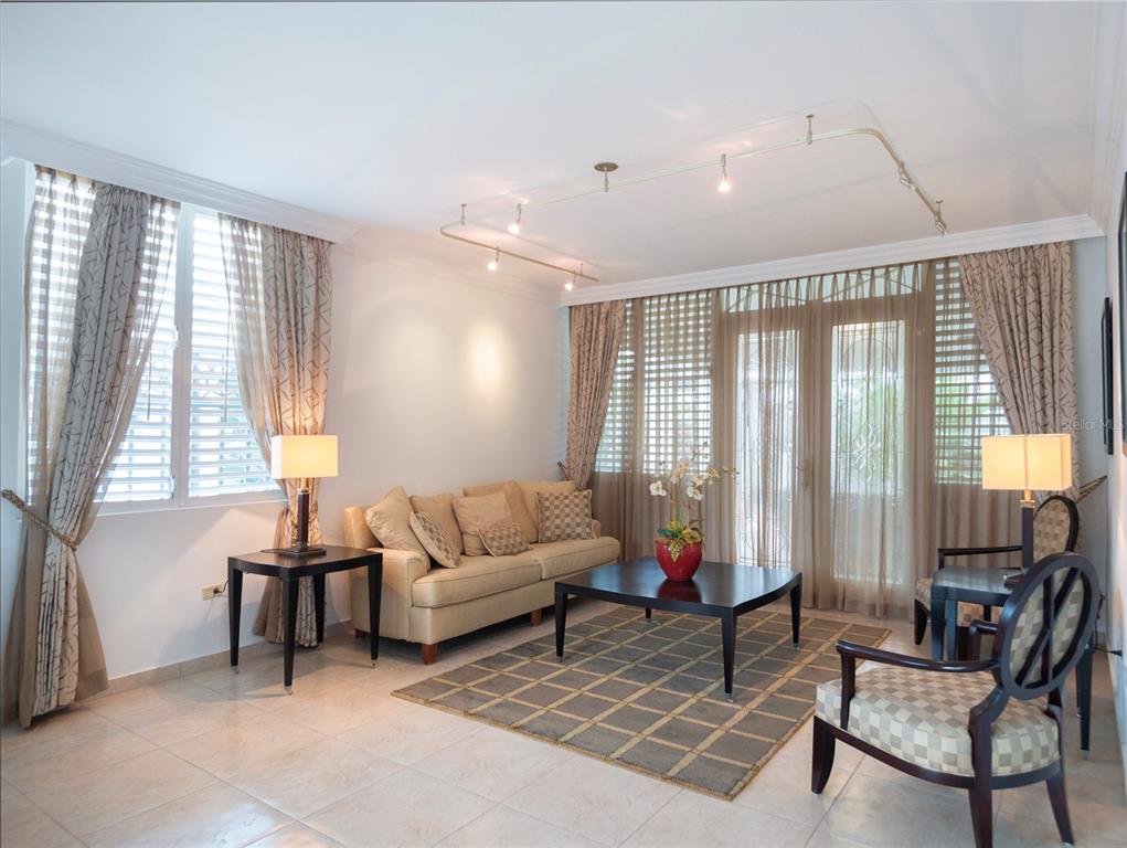 A living room features a beige sofa, a dark coffee table, track lighting, and floor-to-ceiling curtains — #639 DON DIEGO, SAN JUAN, PR