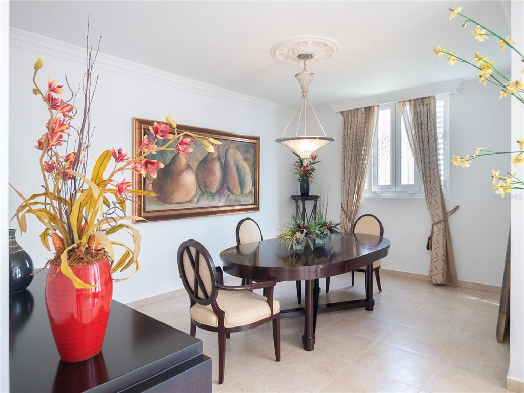 A dining room features a dark wood oval table, four chairs, and a large pear painting — #639 DON DIEGO, SAN JUAN, PR