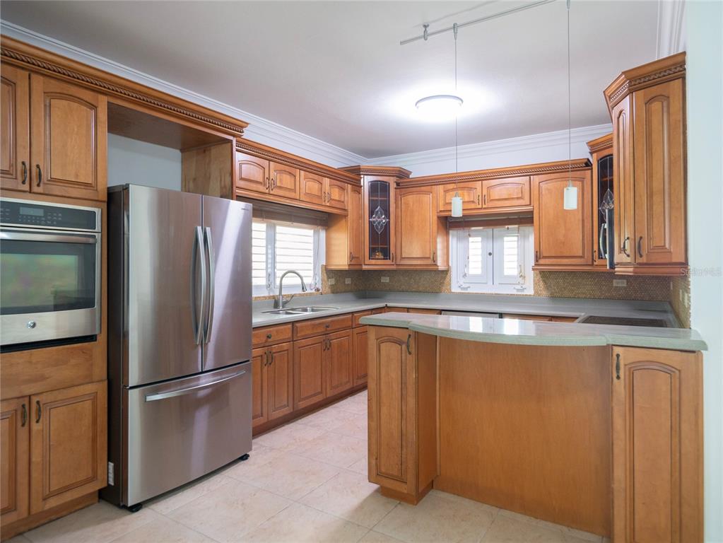 A kitchen features wood cabinets, stainless steel appliances, a peninsula, and tile flooring — #639 DON DIEGO, SAN JUAN, PR