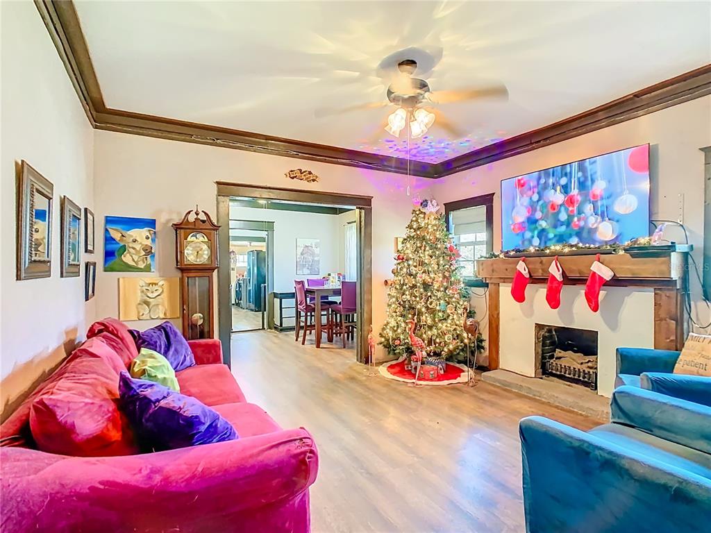 A living room features a red sofa, a Christmas tree, a fireplace, and a dining area — 900 N 30TH STREET, HAINES CITY, FL