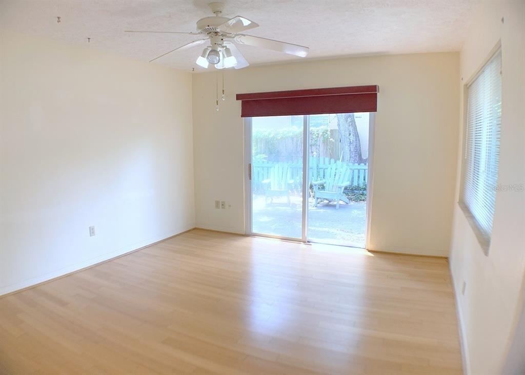 An empty room with light wood flooring, a ceiling fan, and sliding glass patio doors — 2814 W PRICE AVENUE, TAMPA, FL