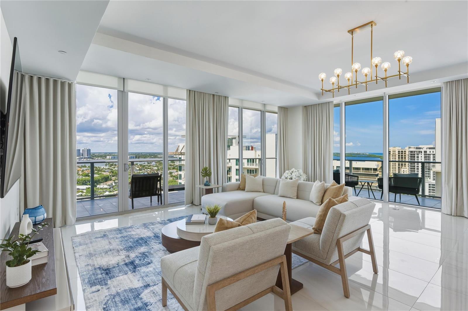 A modern living room features a white sectional, two armchairs, and floor-to-ceiling windows with views — 3100 N Ocean Drive # P1802, Riviera Beach FL 33404, RIVIERA BEACH, FL