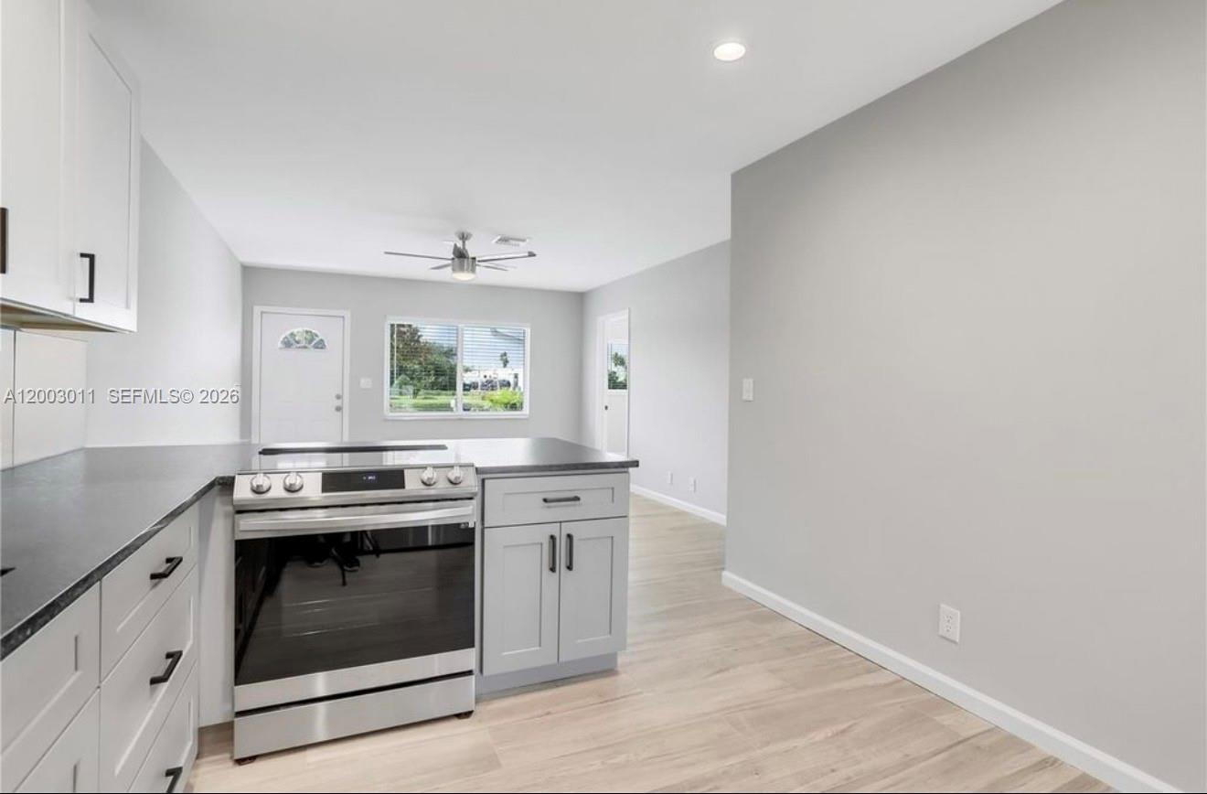 A kitchen features light gray cabinets, stainless steel appliances, and light wood-look flooring — 2550 N Dixie Hwy # 2570, Boca Raton FL 33431, BOCA RATON, FL