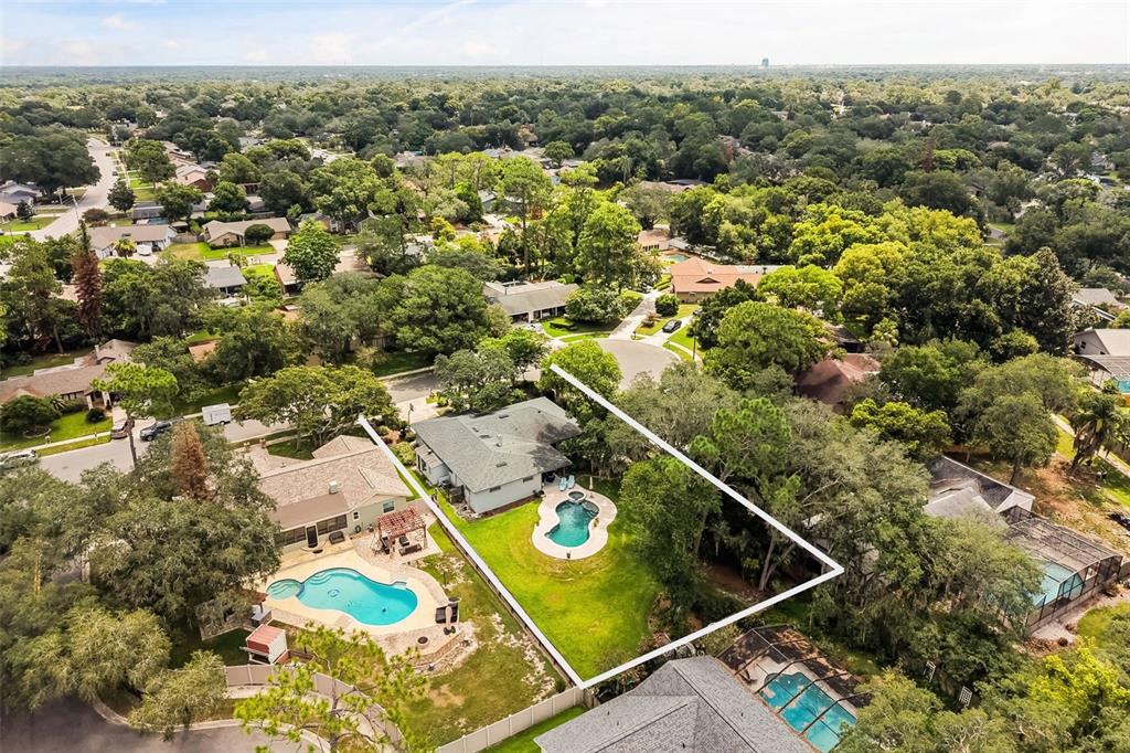 An aerial view shows a residential property with a swimming pool and a fenced backyard — 260 QUEENSBERRY COURT, LONGWOOD, FL