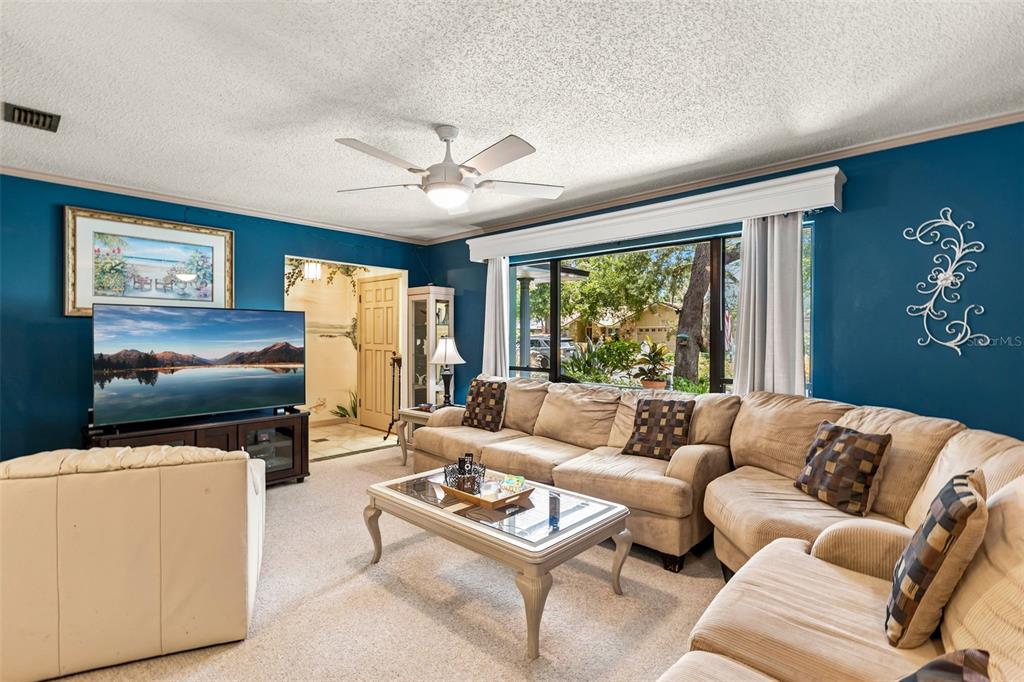 A living room features a large sectional sofa, a coffee table, and a television — 260 QUEENSBERRY COURT, LONGWOOD, FL