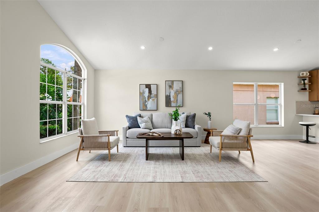 A bright living room features a sofa, two armchairs, a coffee table, and light flooring — 638 TALL OAKS TERRACE, LONGWOOD, FL