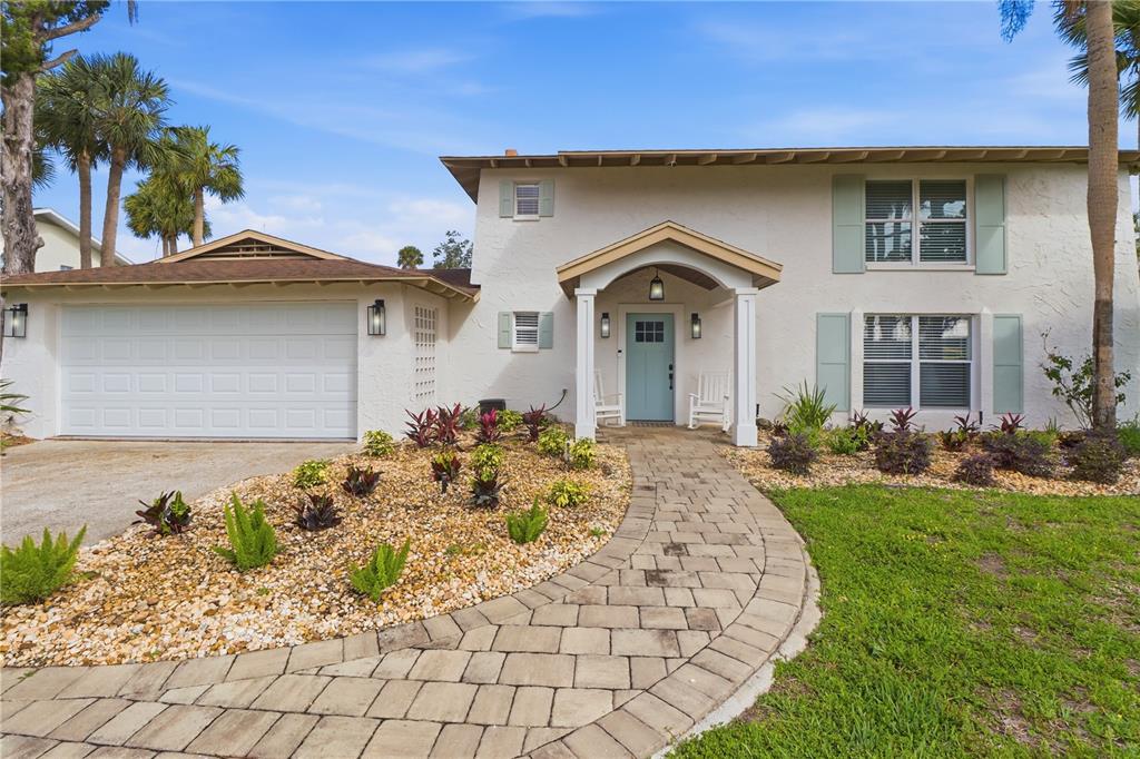 A two-story house with a white stucco exterior, a blue front door, and a paver walkway — 9235 W HARBOR ISLE COURT, CRYSTAL RIVER, FL