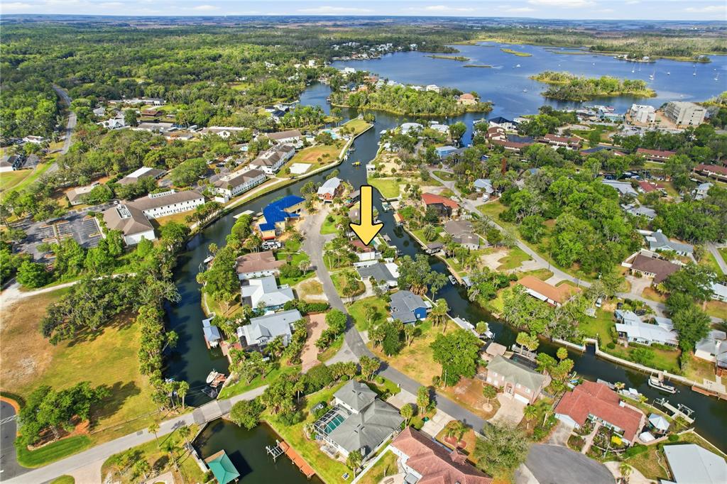 An aerial view shows a residential neighborhood with houses situated along a winding canal — 9235 W HARBOR ISLE COURT, CRYSTAL RIVER, FL
