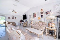 A living room features light-colored furniture, a coffee table, and a wall-mounted television — 14 CEDAR TRACE TERRACE, OCALA, FL