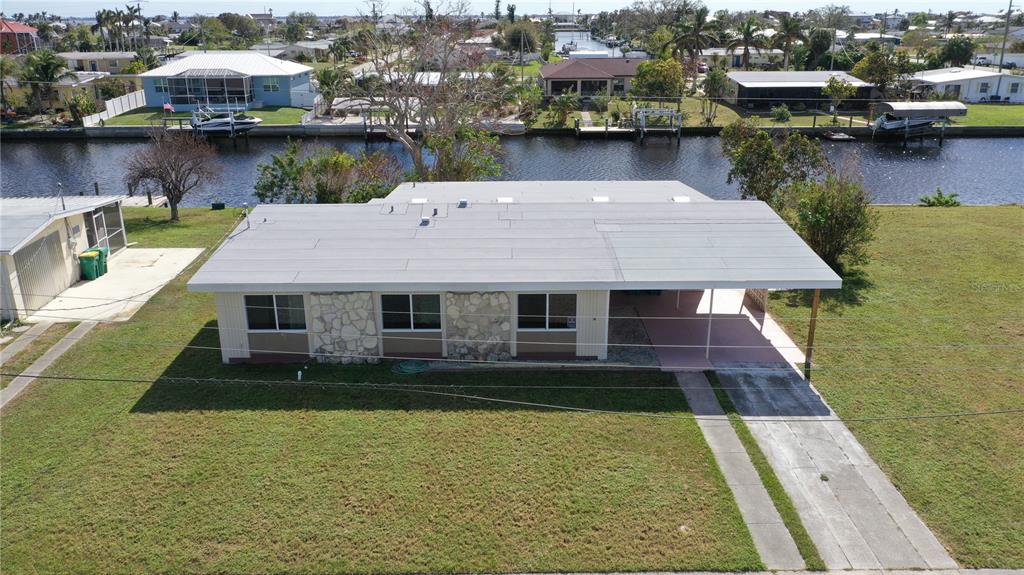 An aerial view of a single-story house with a flat roof, stone accents, and carport — 554 LINDLEY TERRACE, PORT CHARLOTTE, FL