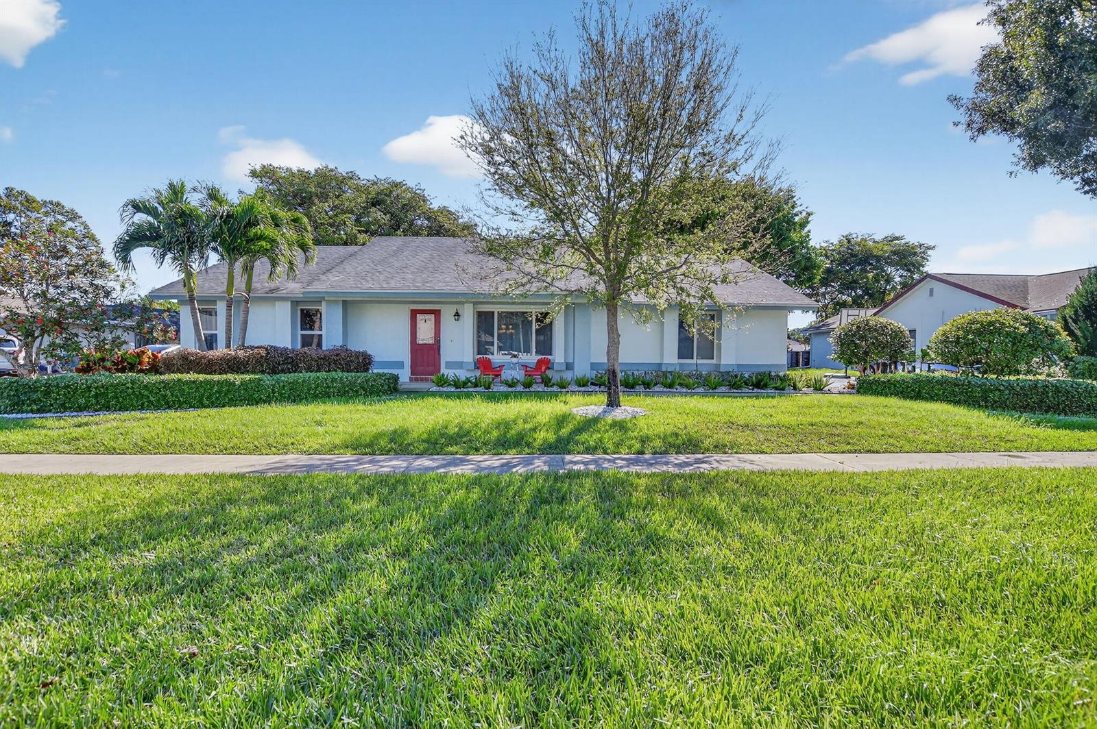 A single-story house with a red front door, a large tree, and a manicured lawn — 18298 102nd Way, Boca Raton FL 33498, BOCA RATON, FL