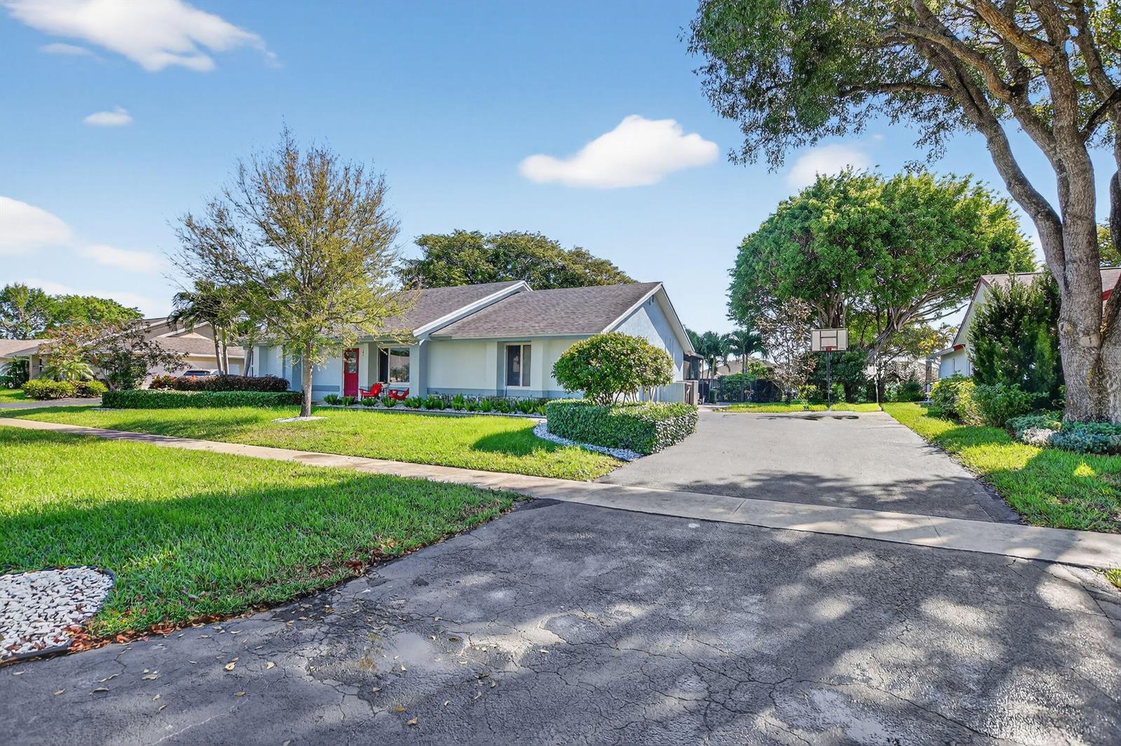A single-story house with a red front door, a paved driveway, and a basketball hoop — 18298 102nd Way, Boca Raton FL 33498, BOCA RATON, FL