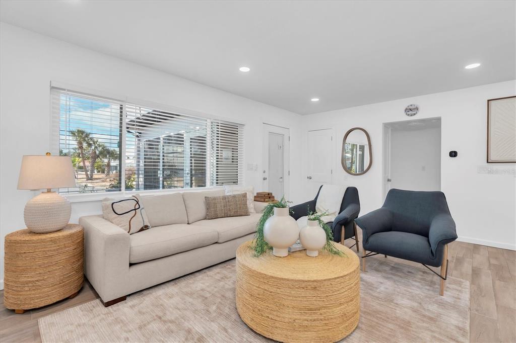A living room features a beige sofa, a round woven coffee table, and two armchairs — 197 LIDO DRIVE, ST PETE BEACH, FL