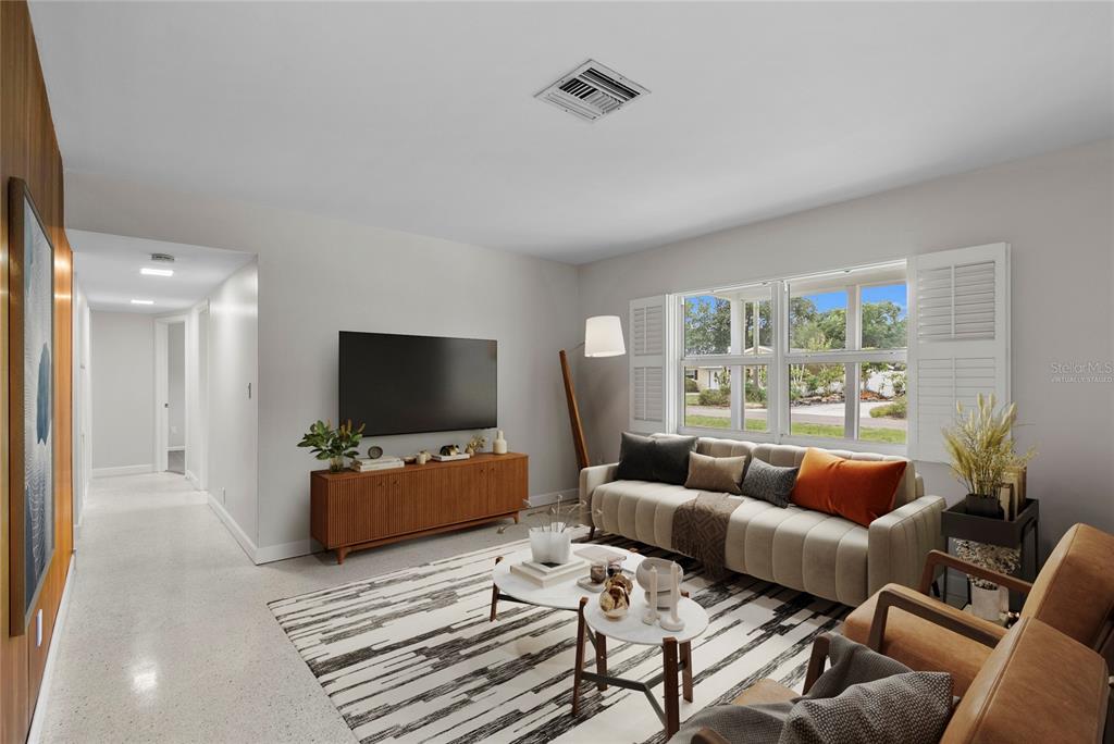 A living room features a sofa, television on a wooden console, and a patterned rug — 2910 W PRICE AVENUE, TAMPA, FL