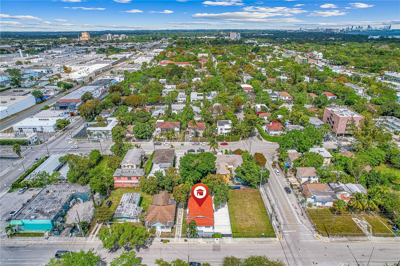 An aerial view shows a red-roofed house with a vacant lot in a residential neighborhood — 473 NE 61st St, Miami FL 33137, MIAMI, FL