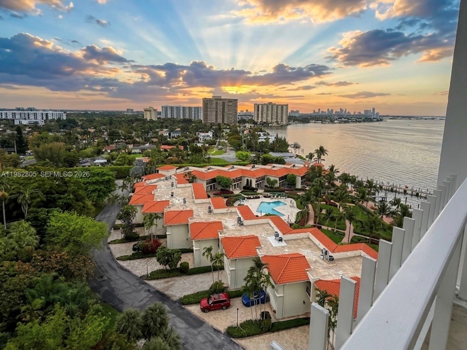 An elevated view shows a residential complex with red-tiled roofs, a pool, and waterfront scenery — 4000 Towerside Ter # 1401, Miami FL 33138, MIAMI, FL