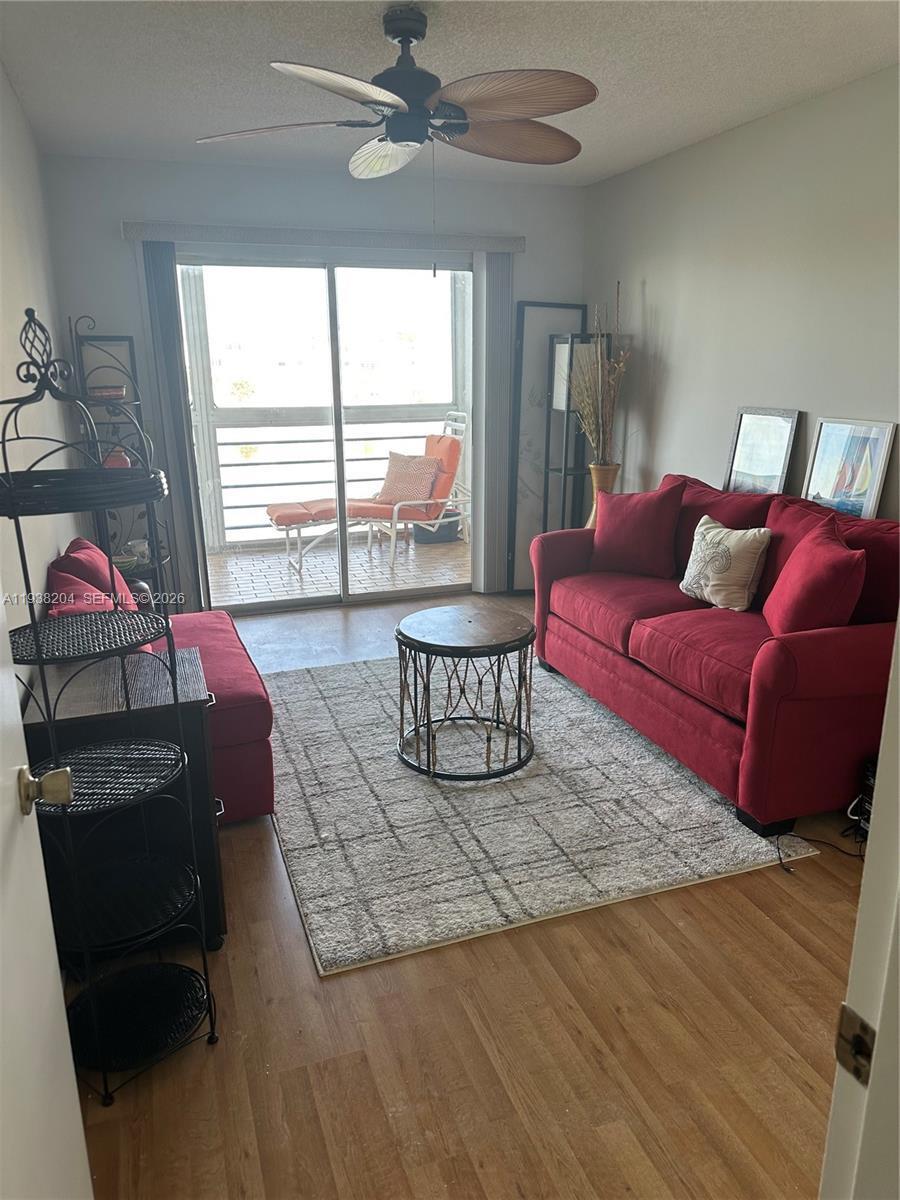 A living room features a red sofa, a round coffee table, and a sliding glass door — 3043 Exeter, Boca Raton FL 33434, BOCA RATON, FL