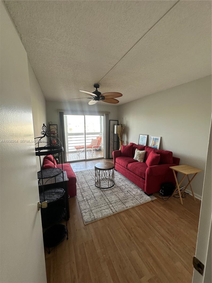 A living room features a red sofa, a patterned area rug, and a sliding glass door — 3043 Exeter, Boca Raton FL 33434, BOCA RATON, FL