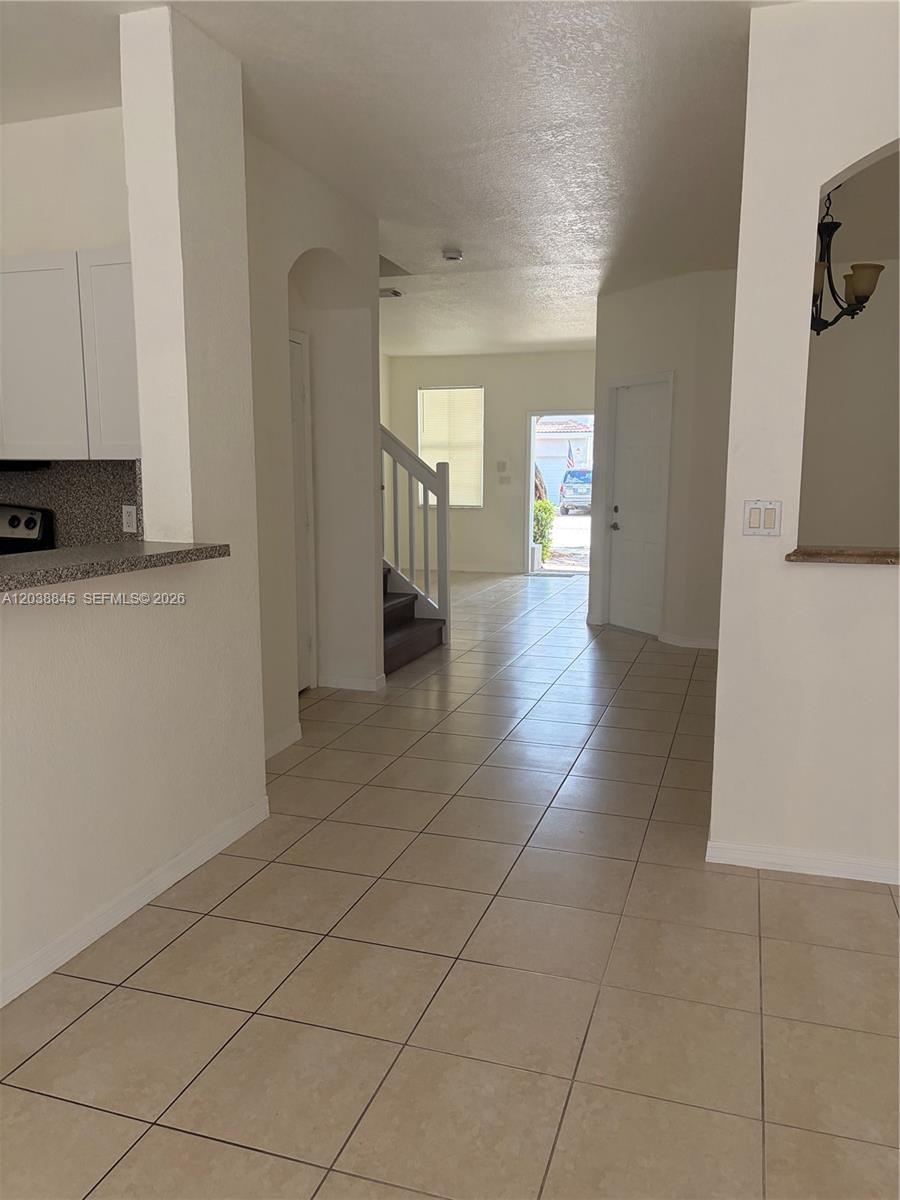 A tiled entryway leads to a staircase, a doorway, and a view of the outdoors — 12393 SW 124th Ter, Miami FL 33186, MIAMI, FL