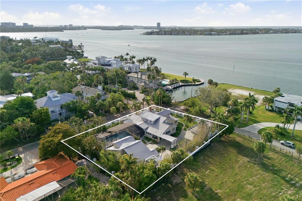 An aerial view of a coastal house with a metal roof, pool, and surrounding landscaping — 604 NORSOTA WAY, SARASOTA, FL
