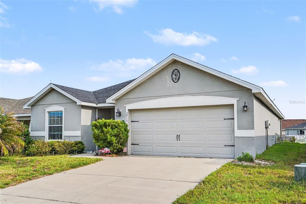 An open-concept kitchen and living area features light wood-look flooring, white cabinetry, and recessed lighting — 3913 WHITE IBIS RD, LAKELAND, FL