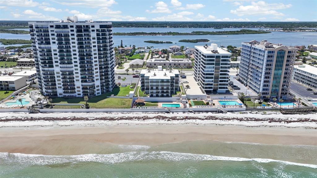 An aerial view of several beachfront high-rise condominiums along a sandy coastline — 3747 S ATLANTIC AVENUE UNIT 2020, DAYTONA BEACH, FL