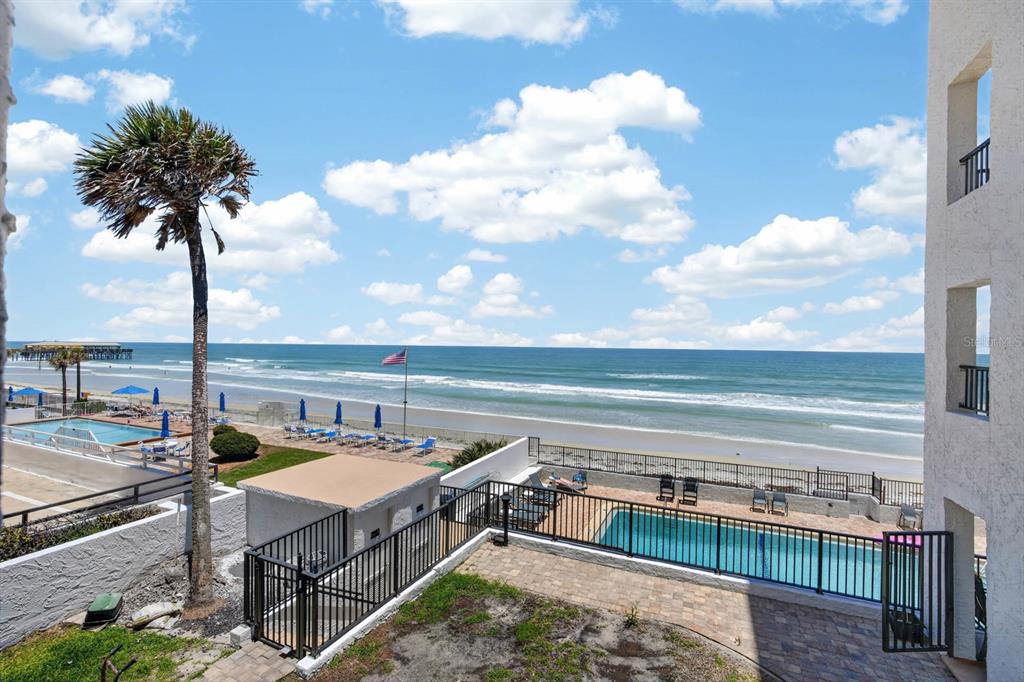 An elevated view of a beachside property featuring two swimming pools and an ocean view — 3747 S ATLANTIC AVENUE UNIT 2020, DAYTONA BEACH, FL