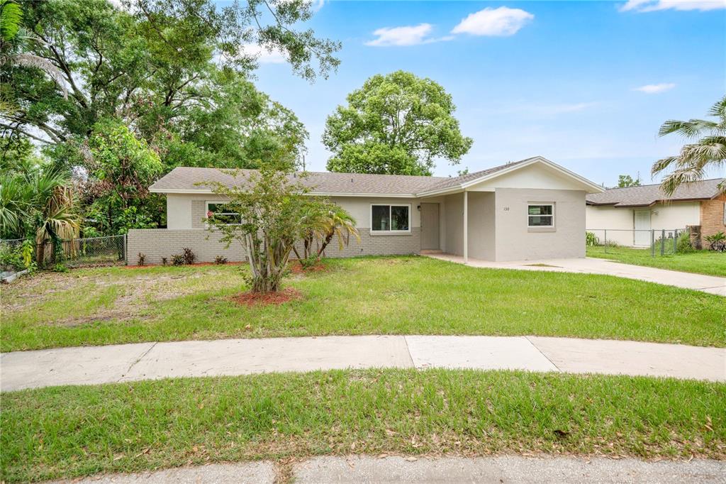 A single-story house with a light-colored brick exterior, a covered entryway, and a grassy lawn — 130 KASEY DRIVE, ORLANDO, FL