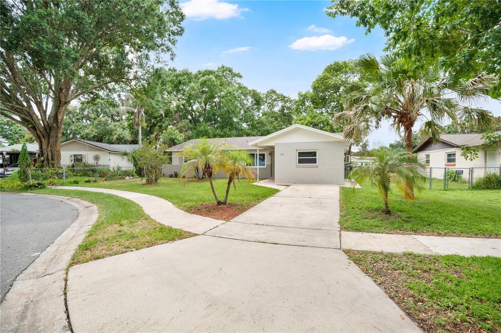 A single-story house with a concrete driveway, a small front lawn, and several palm trees — 130 KASEY DRIVE, ORLANDO, FL