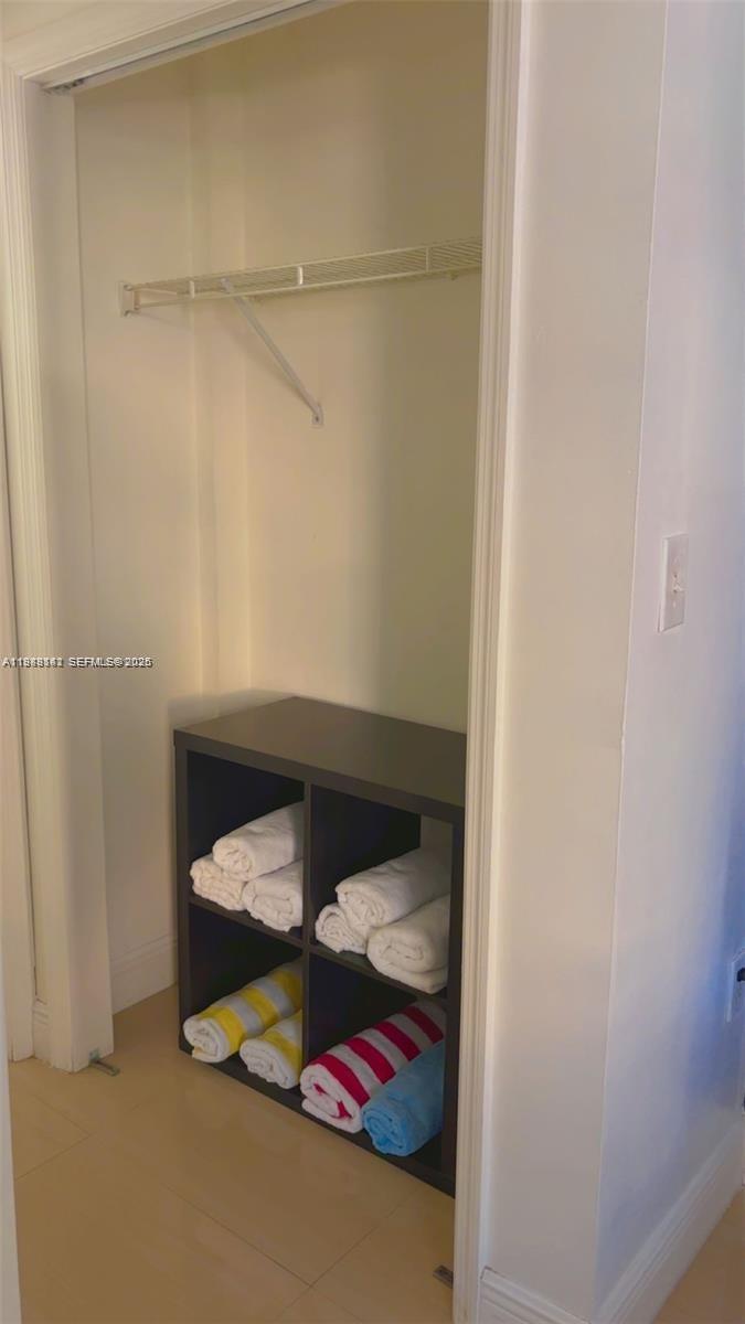 A closet contains a white wire shelf above a dark four-cube storage unit with towels — 710 Washington Ave # 209, Miami Beach FL 33139, MIAMI BEACH, FL