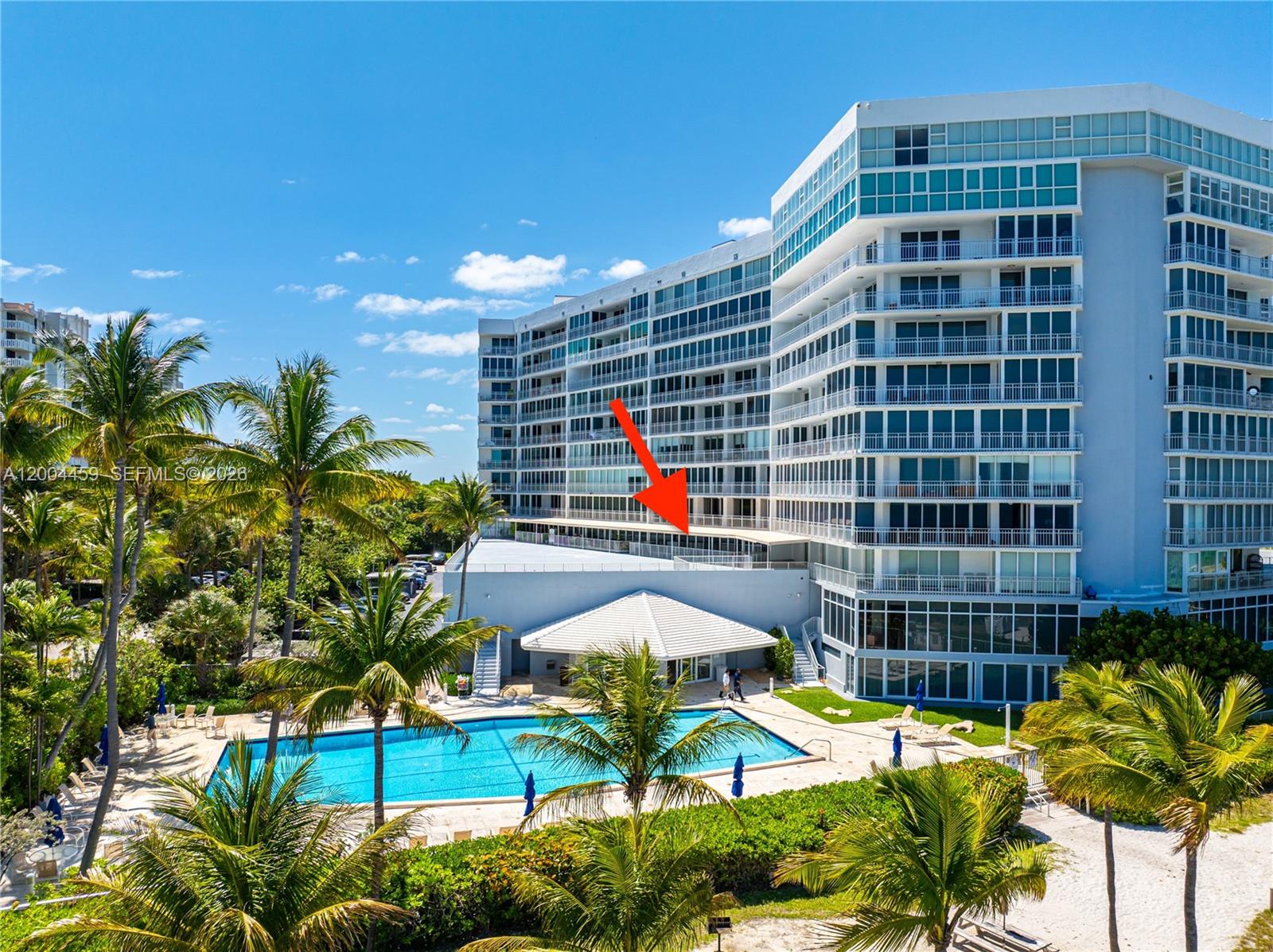 An exterior view of a multi-story residential building with a swimming pool and palm trees — 600 Grapetree Dr, Key Biscayne FL 33149, KEY BISCAYNE, FL