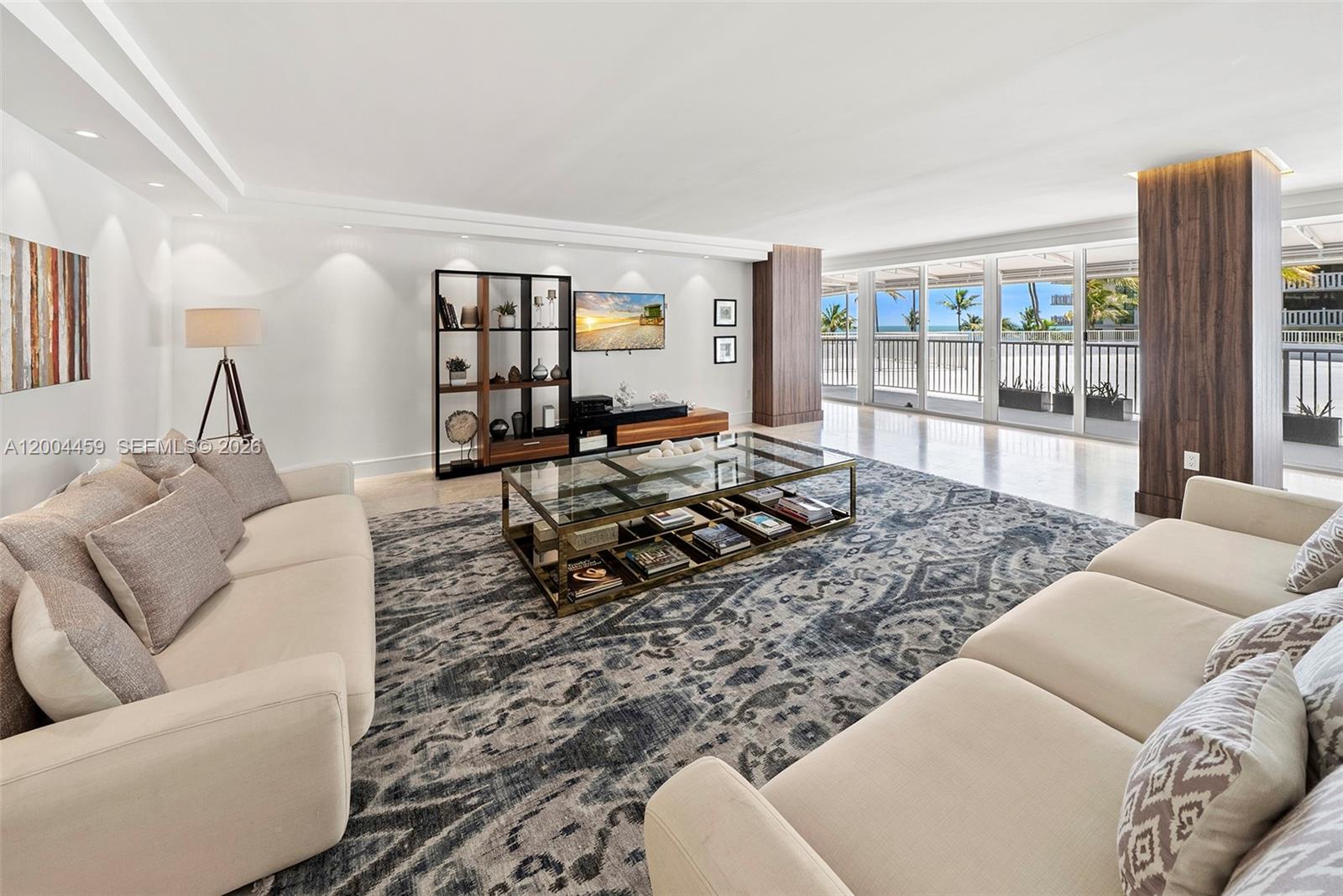 A living room features two beige sofas, a glass coffee table, and floor-to-ceiling balcony windows — 600 Grapetree Dr, Key Biscayne FL 33149, KEY BISCAYNE, FL