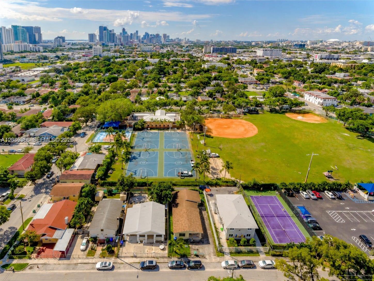 An aerial view shows a neighborhood park with basketball courts, a baseball field, and tennis courts — 118 NW 35th St, Miami FL 33127, MIAMI, FL