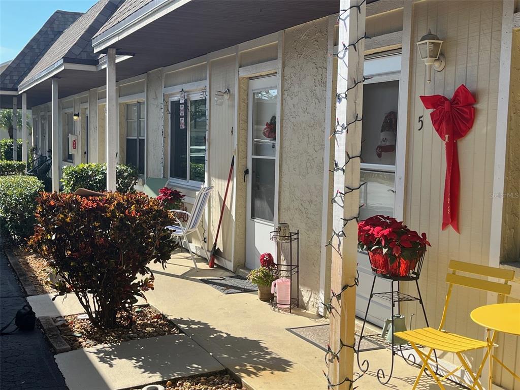 A row of apartment units with beige siding, covered walkways, and small front patios — 670 GREEN VALLEY ROAD UNIT F5, PALM HARBOR, FL