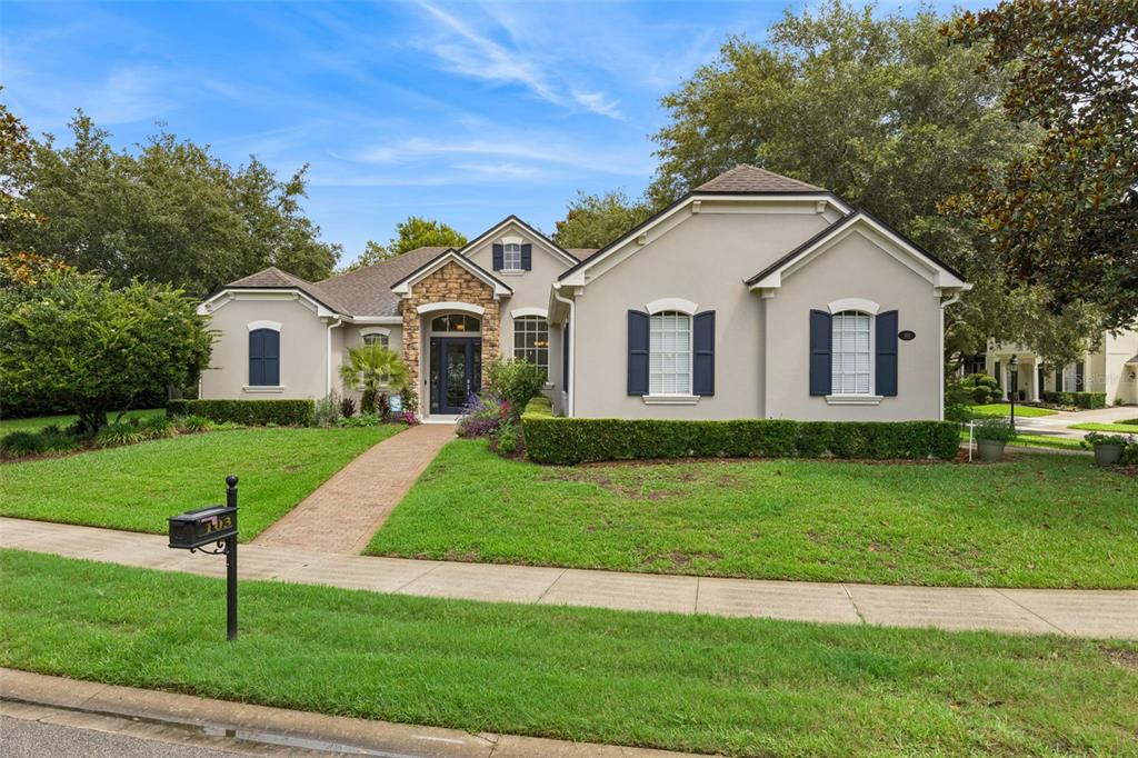 A single-story house with a stone entryway, blue shutters, and a brick walkway — 103 WISTERIA LANE, DELAND, FL