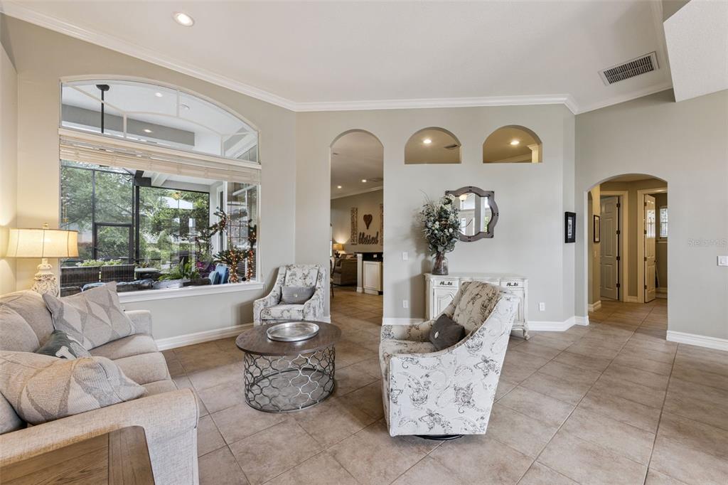 A living room features tile floors, a large arched window, and two arched wall niches — 103 WISTERIA LANE, DELAND, FL