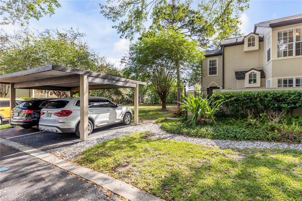 A white SUV and a black SUV are parked under a carport beside a townhouse — 1570 FARRINDON CIRCLE, LAKE MARY, FL