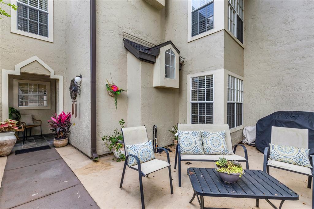 A patio area features outdoor furniture, potted plants, and a beige stucco exterior wall — 1570 FARRINDON CIRCLE, LAKE MARY, FL