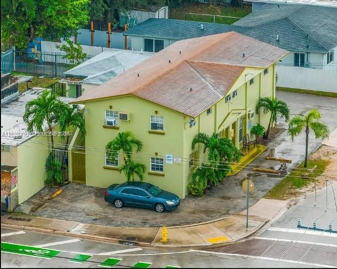 An aerial view shows a two-story, light green apartment building with a brown roof — 1500 NW 69th Ter, Miami FL 33147, MIAMI, FL