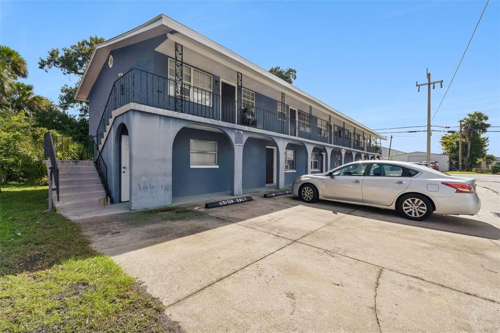 A two-story blue apartment building with an exterior staircase and a concrete parking lot — 601 STATE AVENUE UNIT 2, HOLLY HILL, FL
