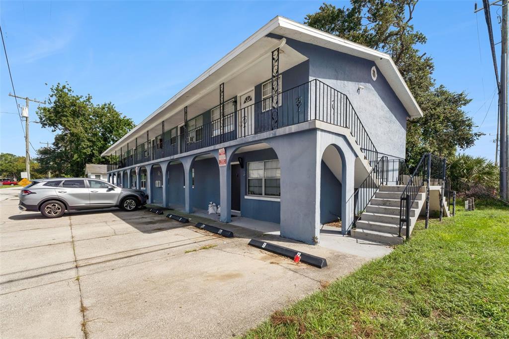 A two-story blue apartment building with an exterior staircase and a parking lot in front — 601 STATE AVENUE UNIT 2, HOLLY HILL, FL
