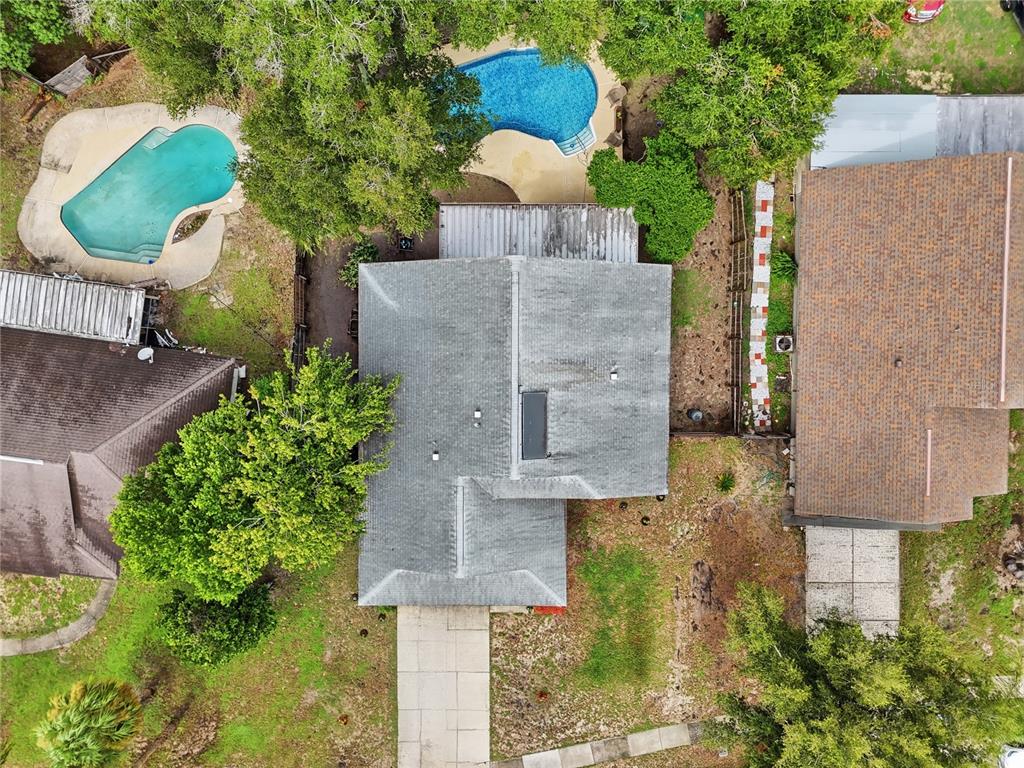 An aerial view shows a house with a gray roof between two properties with pools — 5583 LONG LAKE DRIVE, ORLANDO, FL