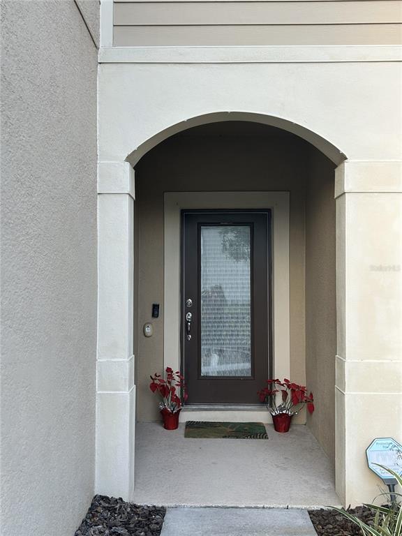 The front entrance features a dark brown door with a glass panel under an arched alcove — 10813 CORSICAN STREET UNIT 10, ORLANDO, FL