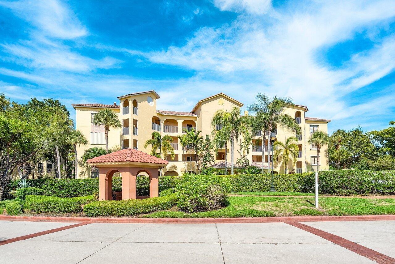 A multi-story apartment building with a tiled roof and a small gazebo in the foreground — 300 Uno Lago Drive # 304, Juno Beach FL 33408, JUNO BEACH, FL