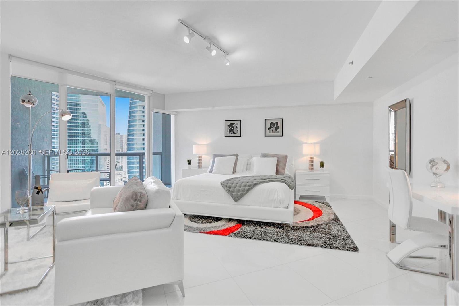 A modern, white-themed bedroom features a large bed, seating area, and floor-to-ceiling windows — 475 Brickell Ave # 3408, Miami FL 33131, MIAMI, FL
